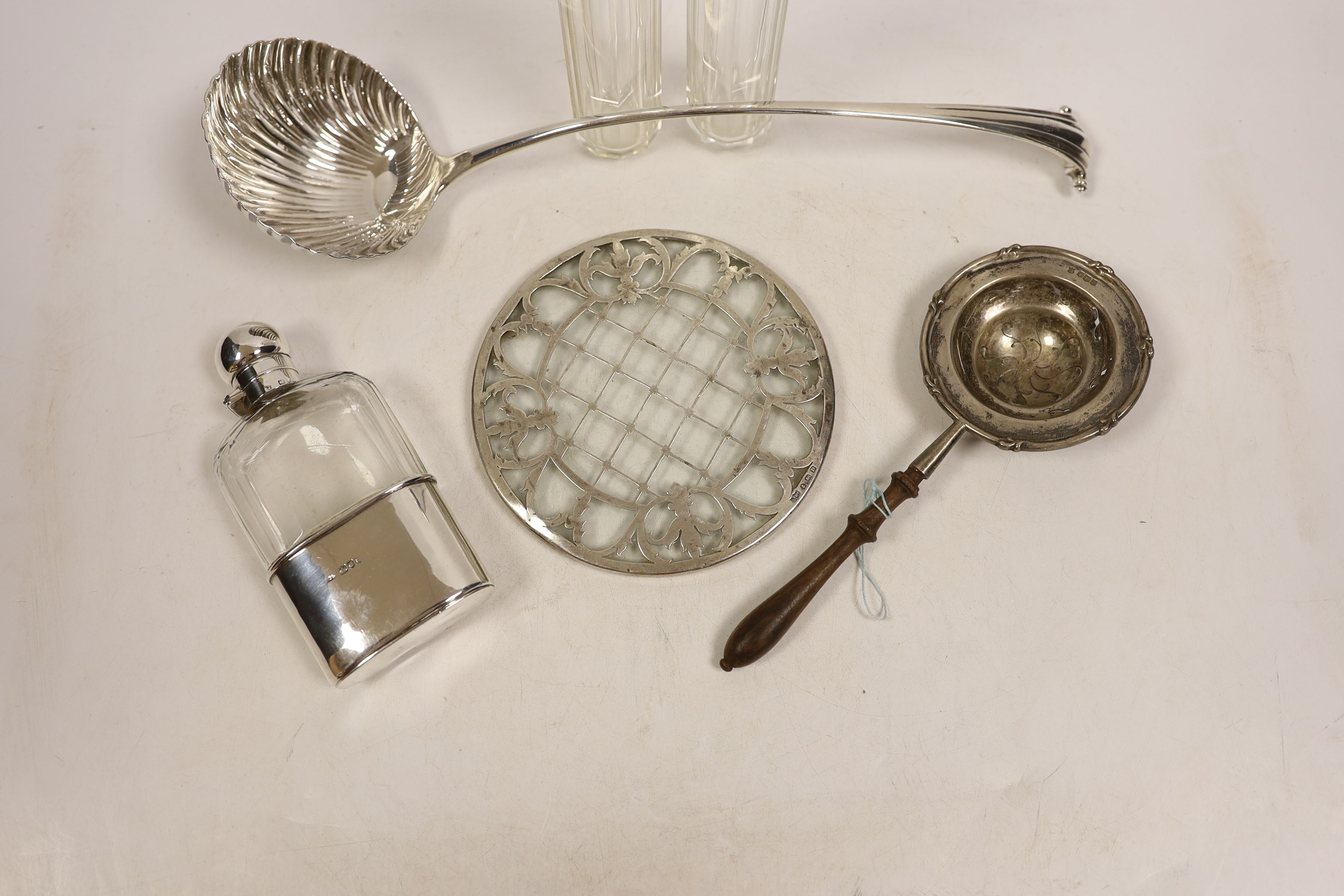 An 18th century silver base mark Onslow pattern soup ladle, indistinct marks and five other items including a silver mounted glass hip flask and a silver tea strainer with wooden handle.